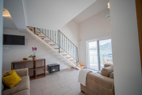a living room with two couches and a staircase at Apartmani Bonaca in Tivat