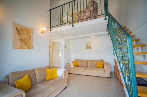 un soggiorno con 2 divani e una scala di Apartmani Bonaca a Tivat
