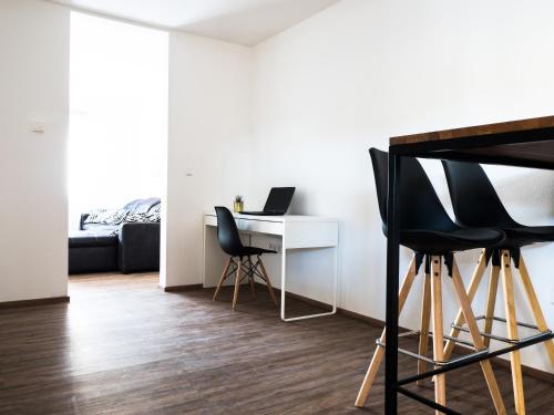a room with a desk with two chairs and a laptop at Wohnung Forst in Forst