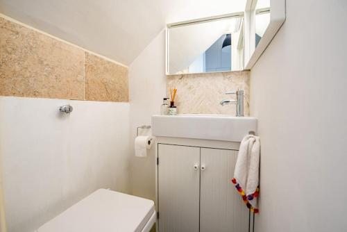 uma casa de banho com um lavatório, um WC e um espelho. em Gorgeous Luxury 2 bed Maida Vale em Londres