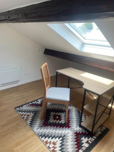 einen Tisch und einen Stuhl in einem Zimmer mit Fenster in der Unterkunft Apartament cozy in Villerupt