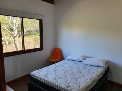 1 dormitorio con cama y ventana en Serena, en Villa Serrana