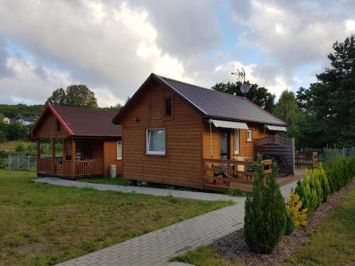 una grande casa in legno con portico e cortile di AgroDana Malinka a Wisełka