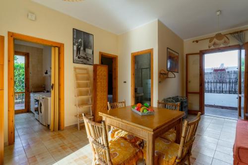 a kitchen and dining room with a table and chairs at Appartamento Rivabella by BarbarHouse in Rivabella