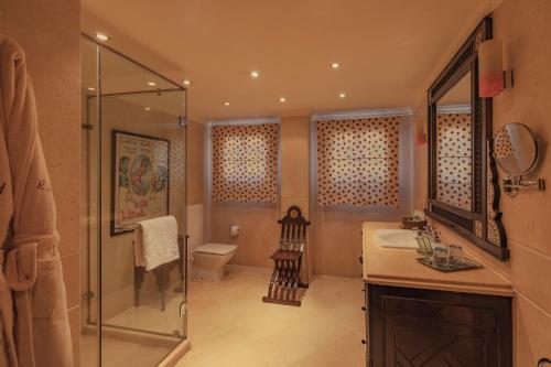 uma casa de banho com um chuveiro, um lavatório e um WC. em Le Riad Hotel de Charme no Cairo