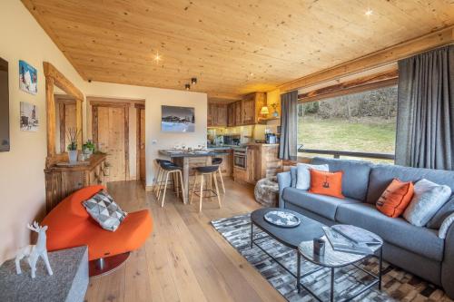 un salon avec un canapé et une table dans l'établissement Les Corneilles - Appartement, à Megève