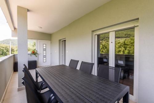 a dining room with a wooden table and chairs at Peninsula Apartments in Žuljana