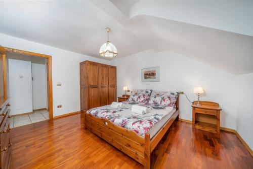 a bedroom with a bed and a table with a lamp at Penthouse Central apartments vista Monte Priesnig in Tarvisio