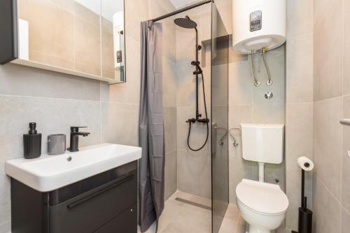 y baño con ducha, lavabo y aseo. en Peninsula Apartments, en Žuljana