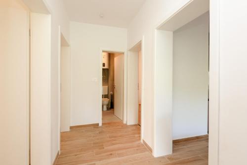 an empty hallway with white walls and wood floors at Peninsula Apartments in Žuljana