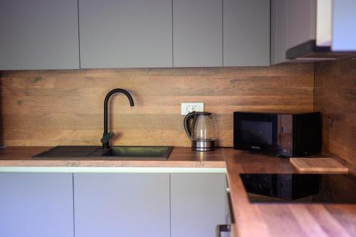 a kitchen with a sink and a microwave at Peninsula Apartments in Žuljana