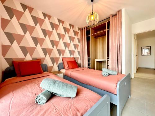 - une chambre avec 2 lits et un mur géométrique dans l'établissement Duplex - Vue Mer exceptionnelle - Quartier Euromed-avec Box, à Marseille