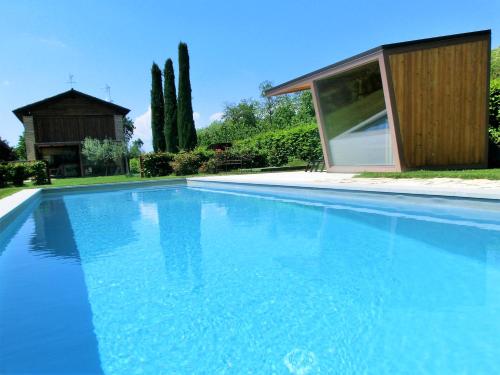 una gran piscina azul frente a una casa en Agriturismo Dolce Colle, en Volpago del Montello