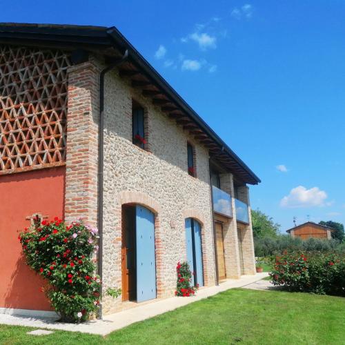 a brick building with a blue door and some flowers at Agriturismo Dolce Colle in Volpago del Montello