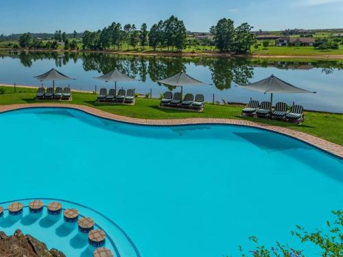 an aerial view of a lake with chairs and umbrellas at Blue Zone Leisure at Pine Lake Inn Resort in White River