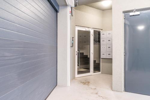 a garage door in a bathroom with a mirror at Brand new two room apartment #34 with free secure parking in the center in Prague