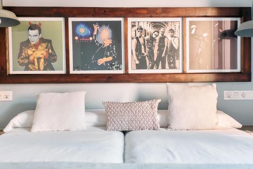 sala de estar con sofá blanco y cuadros en Apartamentos One, en Teruel