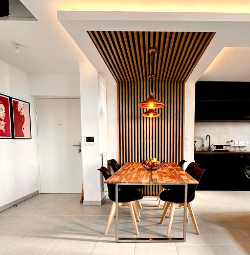 une salle à manger avec une table et des chaises en bois dans l'établissement Duplex - Vue Mer exceptionnelle - Quartier Euromed-avec Box, à Marseille