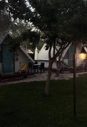 a tree and a house with a table and a playground at Sunseabeach in Marzamemi