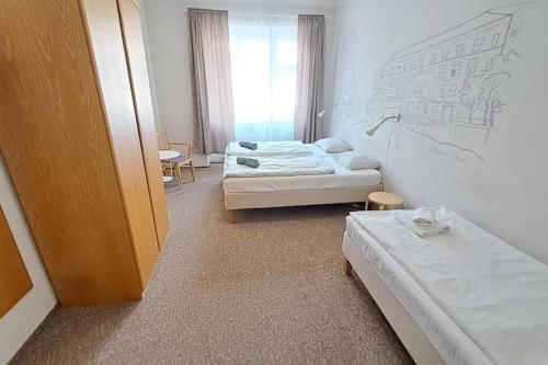 een kleine kamer met 2 bedden en een raam bij Comfortable apartment sleeps 6 in Praag