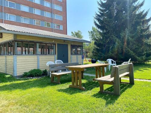 een picknicktafel en banken voor een gebouw bij Aava's apt. FREE Parking in Pori