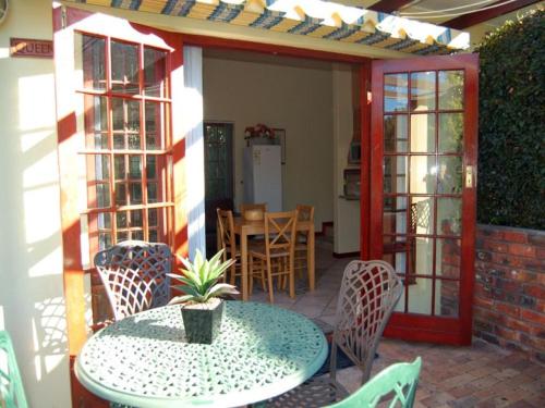a patio with a table and chairs and a dining room at Ascot Gardens Self Catering in Cape Town