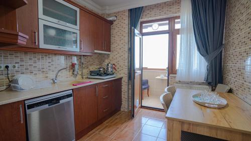 a kitchen with wooden cabinets and a counter top at GRAND FAMILY HOME in Soğuksu
