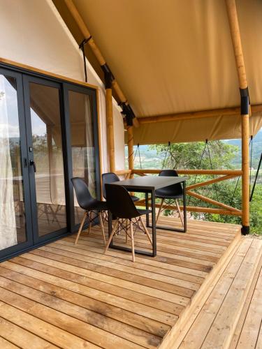 un porche cubierto con mesa y sillas en Agriturismo Casa del Principe, en Torre Bormida