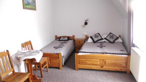 1 dormitorio con 2 camas, mesa y sillas en Dom Wypoczynkowy ''Elżbieta'' en Poronin