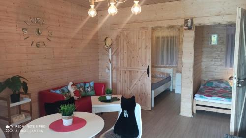 salon z czerwoną kanapą i łóżkiem w obiekcie Domki letniskowe MałaMi Chłopy,Mielno, Sarbinowo w Chłopach