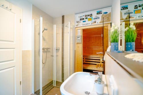 ein Bad mit einer Dusche und einem Waschbecken in der Unterkunft Die Kornblume in Zingst