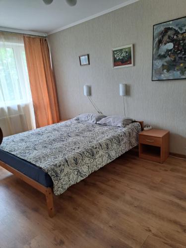 a bedroom with a bed and a table and a window at Ziemielu mols apartaments/pirmā līnija pie jūras in Liepāja