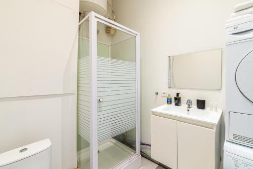 La salle de bains blanche est pourvue d'une douche en verre et d'un lavabo. dans l'établissement Chevalier Paul-Charmant-Mezzanine - 4 personnes, à Marseille