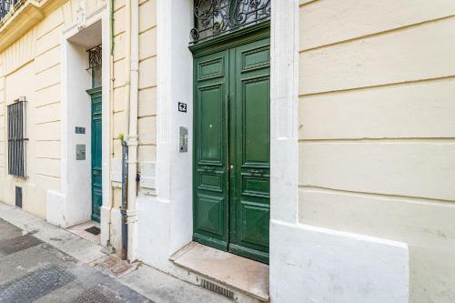 une porte verte sur le côté d'un bâtiment dans l'établissement Chevalier Paul-Charmant-Mezzanine - 4 personnes, à Marseille
