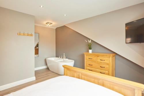 a bathroom with a bed and a sink and a tub at Host & Stay - The Old Jail Barber's Shop in Seamer