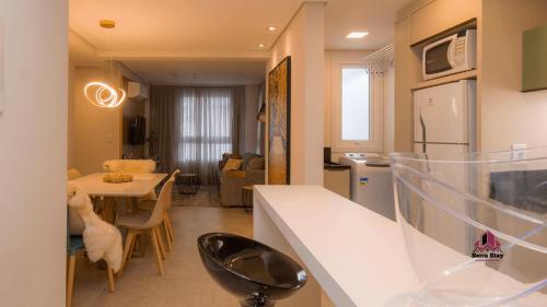 a kitchen and living room with a table and a dining room at Apto Luxo Vila di Tondo Area Lazer na Cobertura in Bento Gonçalves