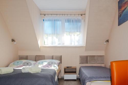Postel nebo postele na pokoji v ubytování Sztil - Apartamenty i drewniane domki