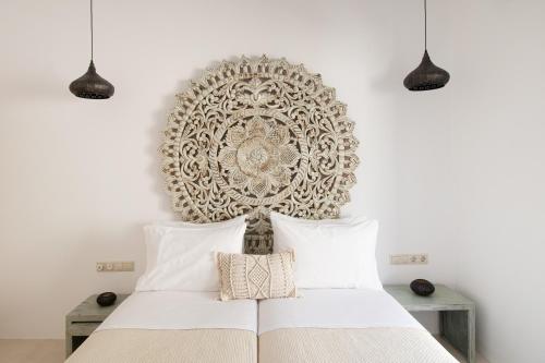 a bedroom with a white bed and a large wall art at Youtopia Ios Villas in Ios Chora