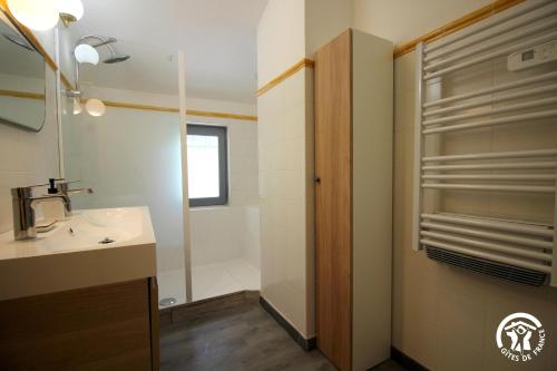 ein Bad mit einem Waschbecken und einer Dusche in der Unterkunft Gîte Aussos 