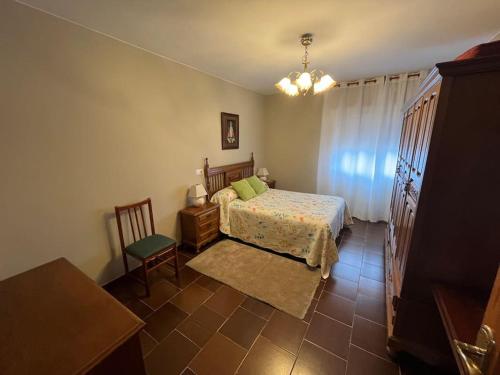 een slaapkamer met een bed, een tafel en een stoel bij Casa El Lloreu in Antimio de Abajo