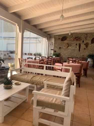 ein Restaurant mit weißen Bänken und Tischen sowie Tischen und Stühlen in der Unterkunft Bed e Breakfast Erica in Conflenti Inferiore