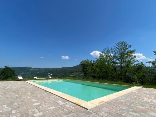 a swimming pool in a yard with a tile floor at Agriturismo Casa del Principe in Torre Bormida