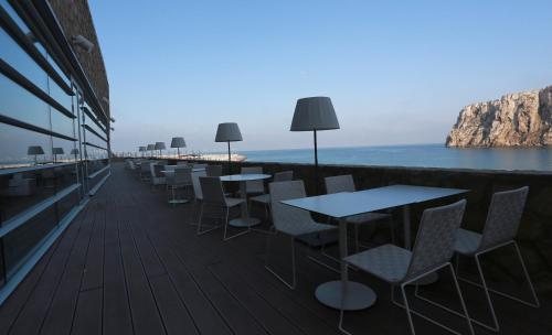 a row of tables and chairs on a balcony overlooking the ocean at Mercure Quemado Al-Hoceima Resort in Al Hoceïma