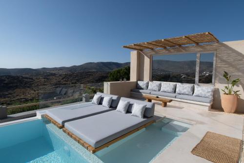 a patio with a couch and a swimming pool at Youtopia Ios Villas in Ios Chora