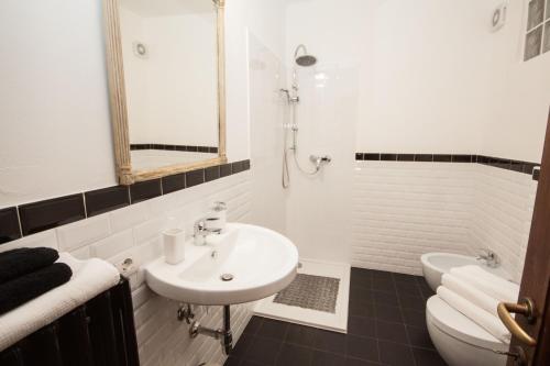 a white bathroom with a sink and a toilet at Vista Menaggio Centro in Menaggio