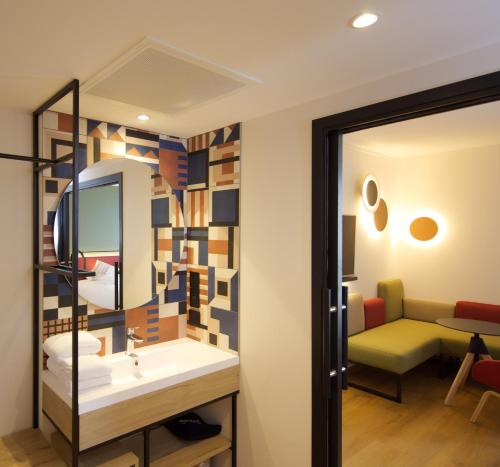 a bathroom with a sink and a mirror at Campanile PRIME - Rungis Orly in Chevilly-Larue