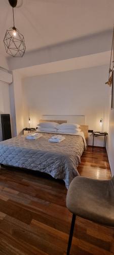 um quarto com uma cama grande e uma cadeira em A10 SecretHouse em Atenas