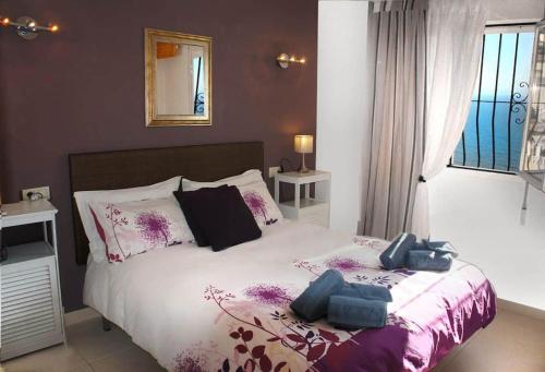 - une chambre avec un grand lit violet et blanc dans l'établissement VILLA BUENA VISTA, à Cumbre del Sol