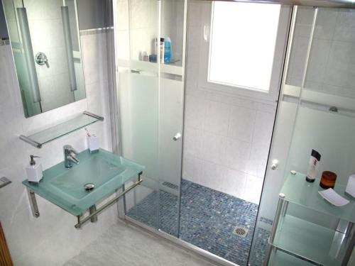 La salle de bains est pourvue d'un lavabo vert et d'une douche. dans l'établissement VILLA BUENA VISTA, à Cumbre del Sol