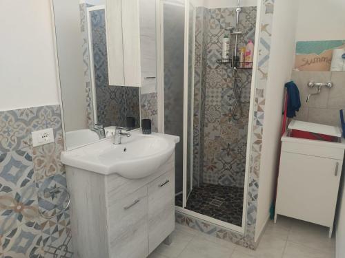 a bathroom with a white sink and a shower at Casa Vacanze Lungomare in Piombino